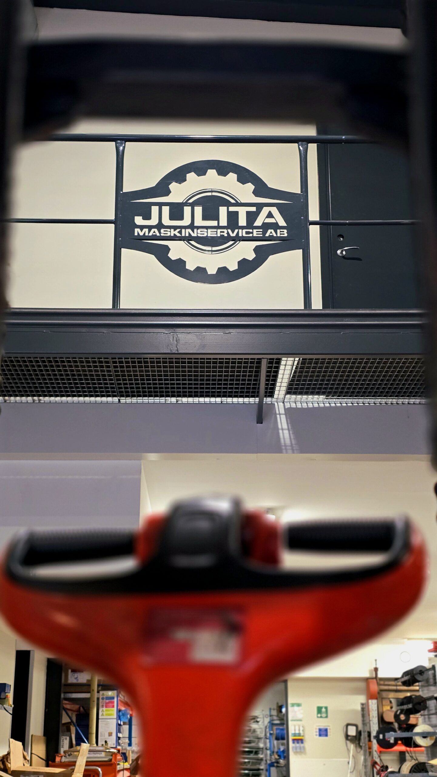 Julita Maskinservice logotyp på räcke i verkstadslokalen